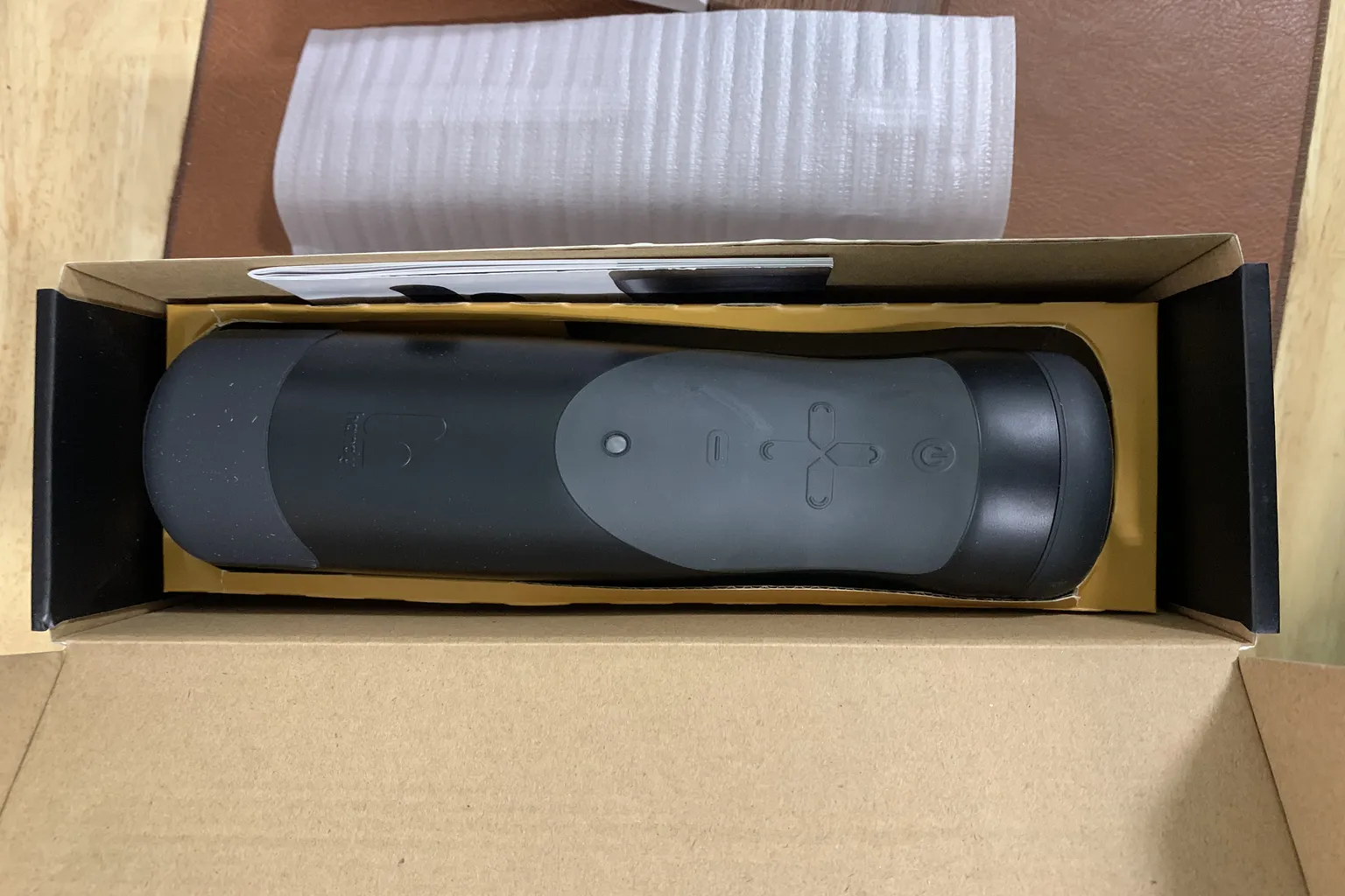 打開包裝後的 The Handy 主機躺在盒內的開箱畫面，顯示控制按鍵與機身設計