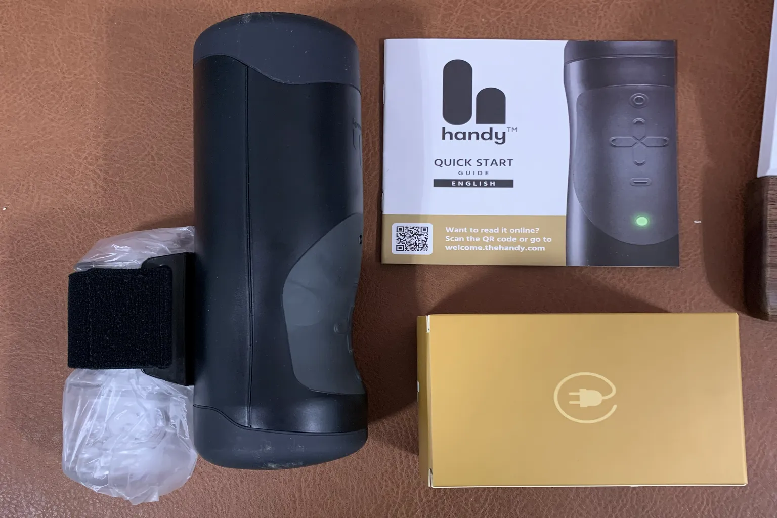 The Handy 主機、說明書與配件整齊排列的開箱內容展示