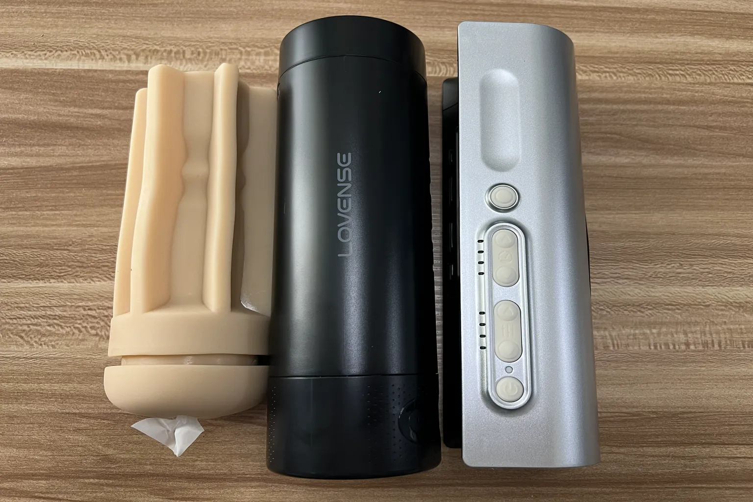 Lovense Solace Pro 飛機杯拆解展示，左側為可拆卸內膽，中間為黑色杯體，右側為銀色主機